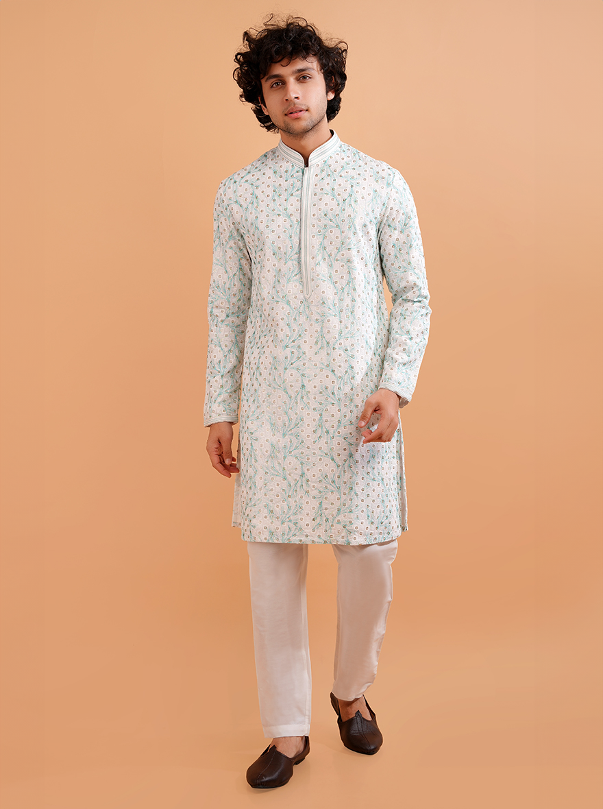 Stylish men's white silk kurta pajama, perfect for celebrations with intricate green details.