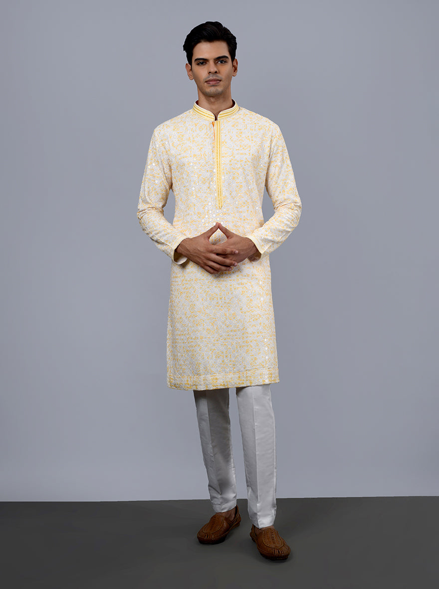 Exquisite embroidery on this cream and yellow kurta pajama enhances its charm.