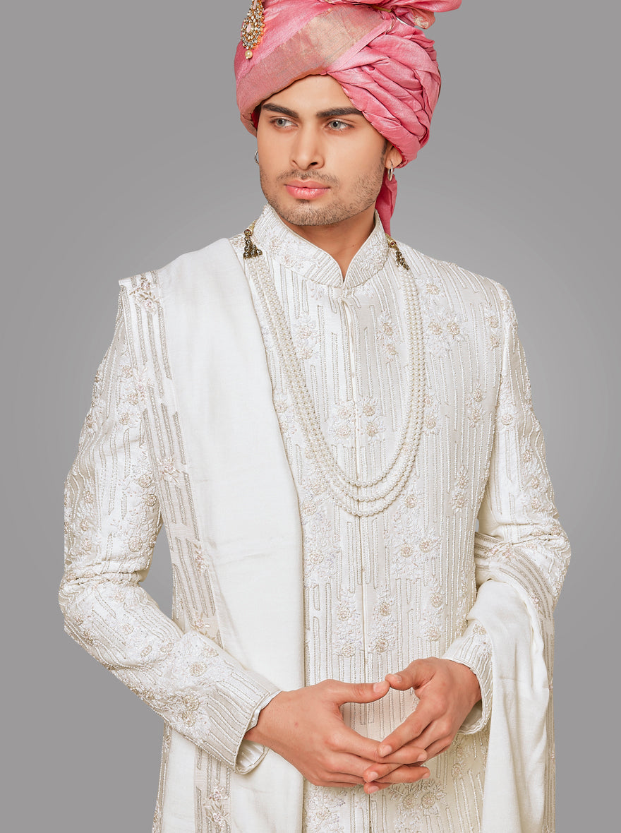 This cream silk blend sherwani features intricate embroidery, adding a touch of elegance to your look.