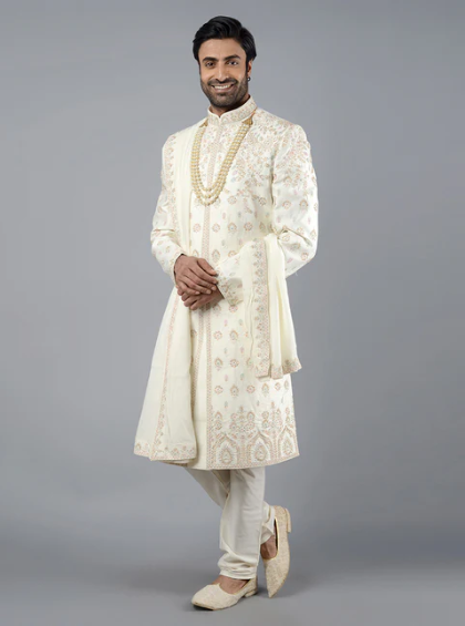 Tailored from a luxurious silk blend, this cream sherwani features intricate Resham and beadwork.