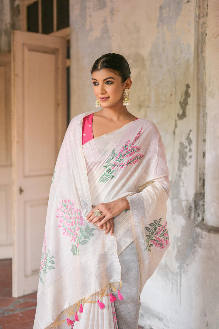 Muga cotton saree with intricate floral weave, zari patta on pallu, and tassels