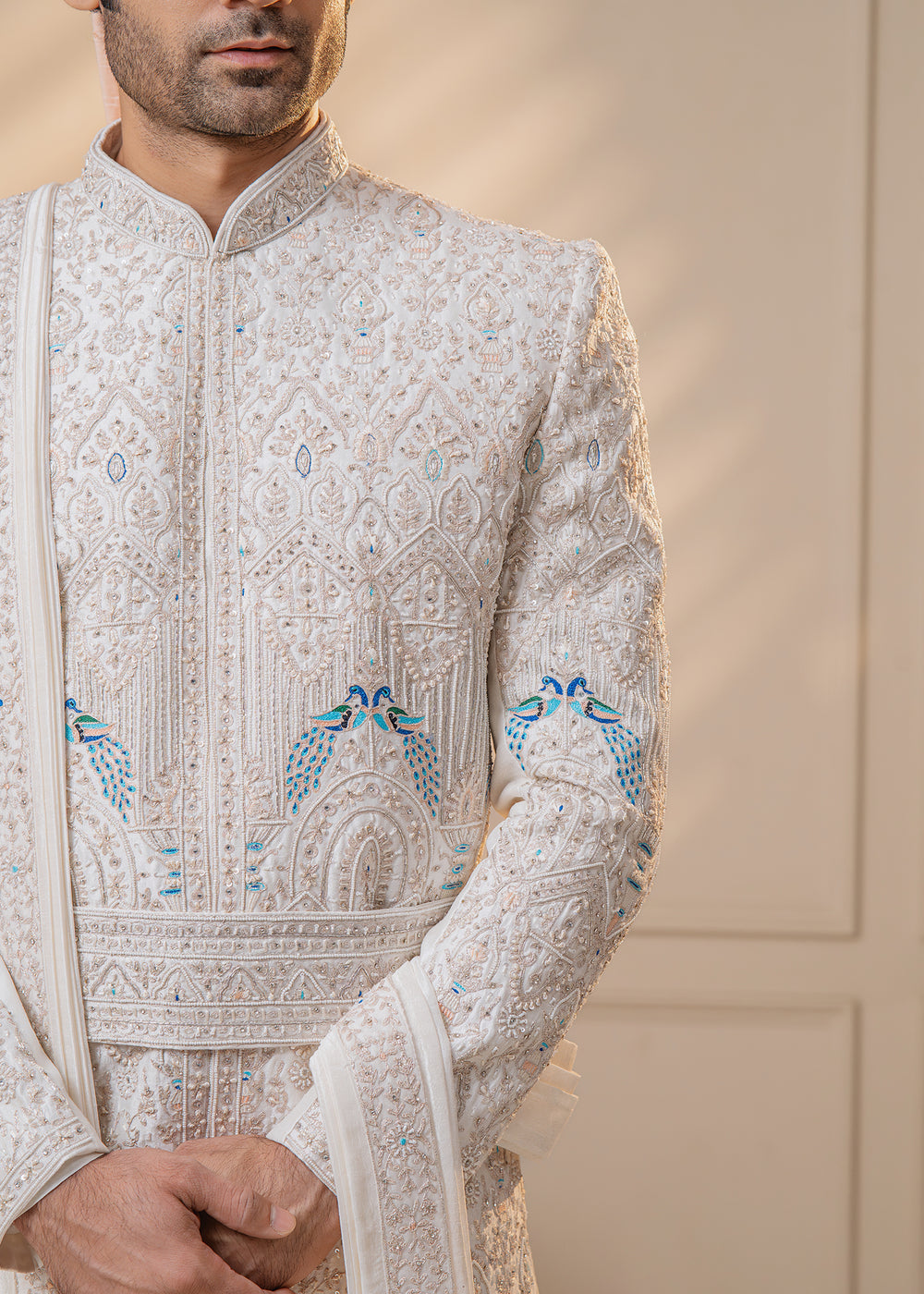 Make a statement on your special day with our traditional white sherwani, adorned with intricate motifs and embroidery, embodying elegance and sophistication.