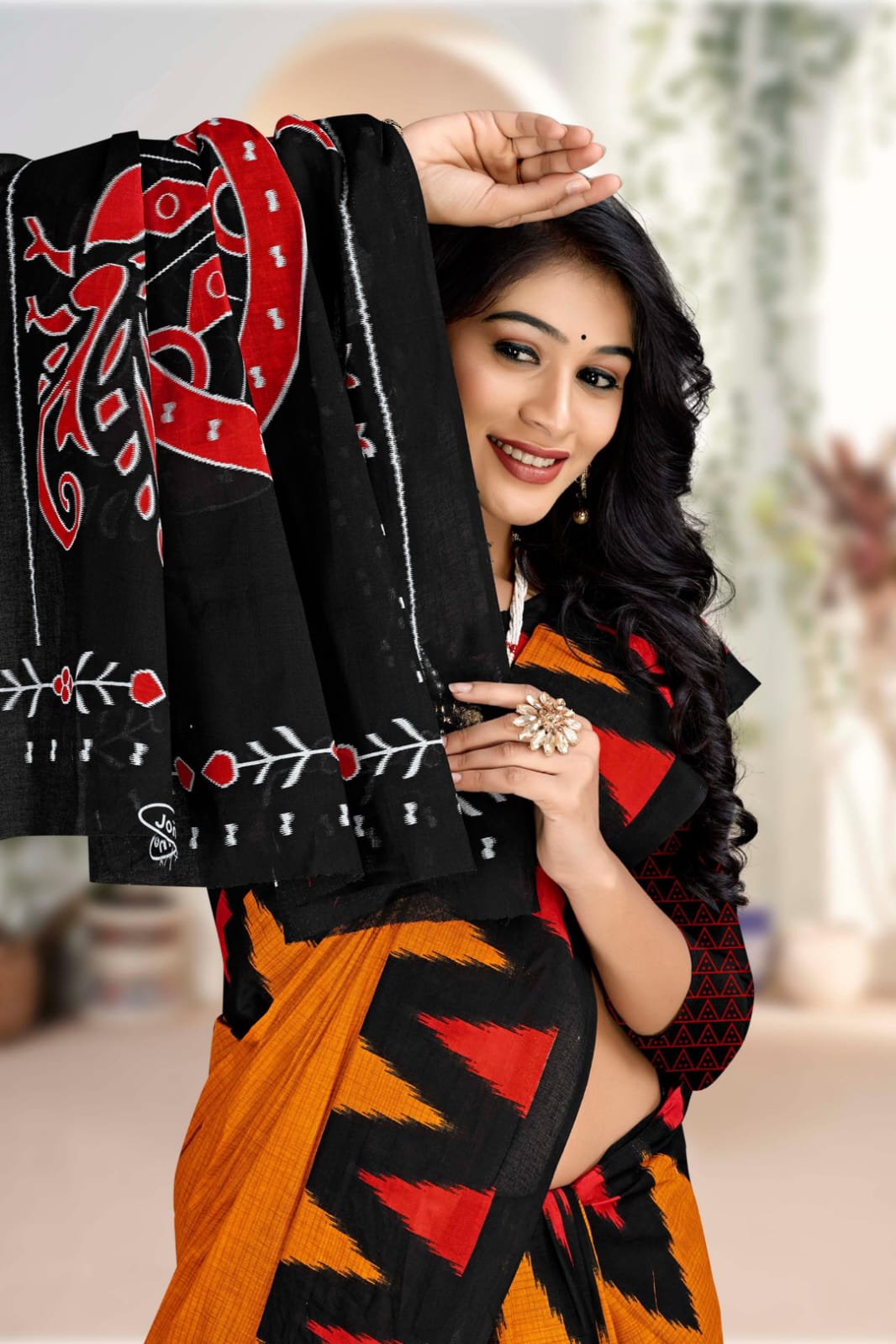 Designer black and orange handloom cotton saree with tribal art, perfect for special cultural events.