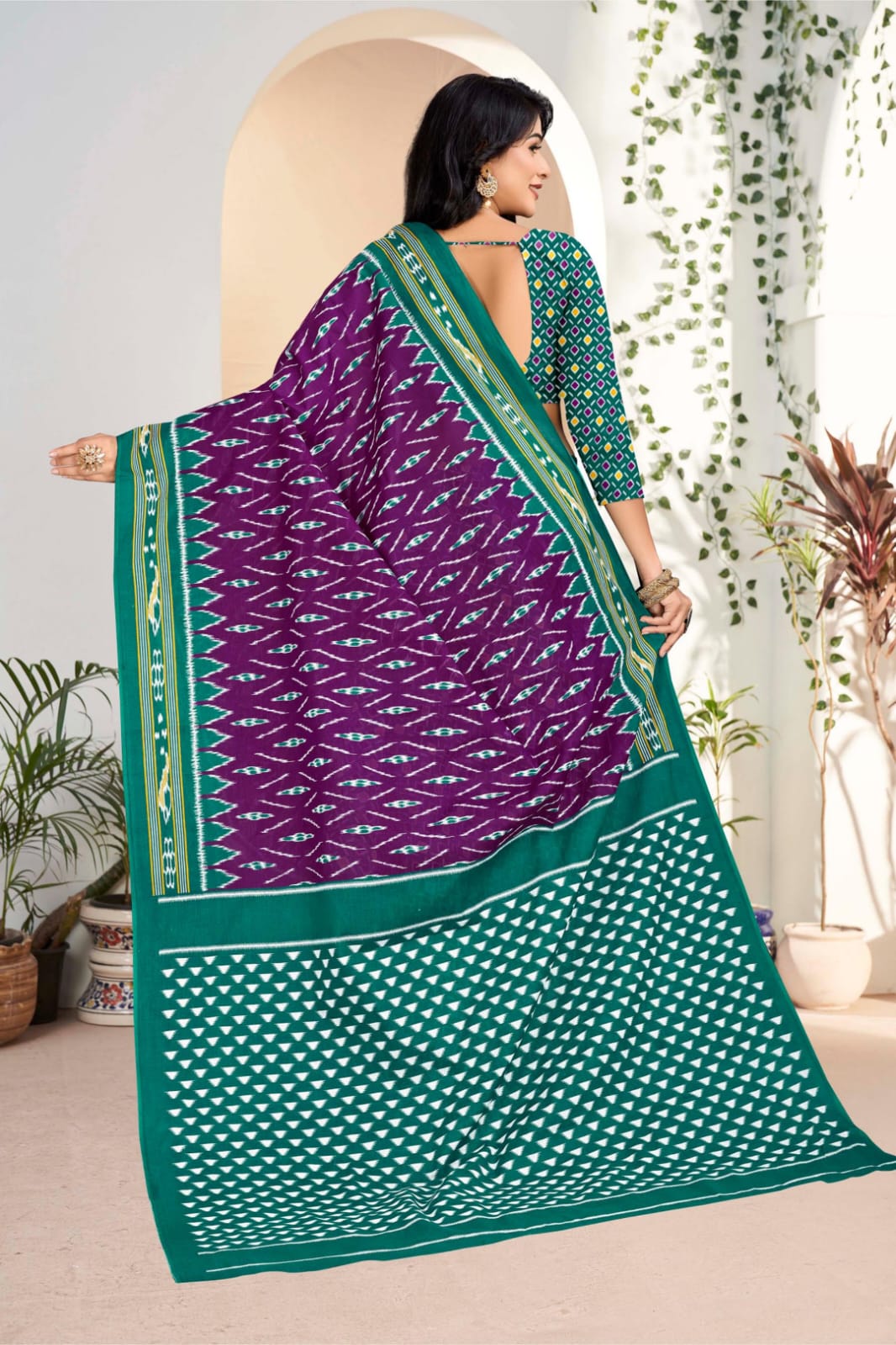 Handloom cotton saree in purple and pine green, featuring intricate tribal patterns for a traditional look.