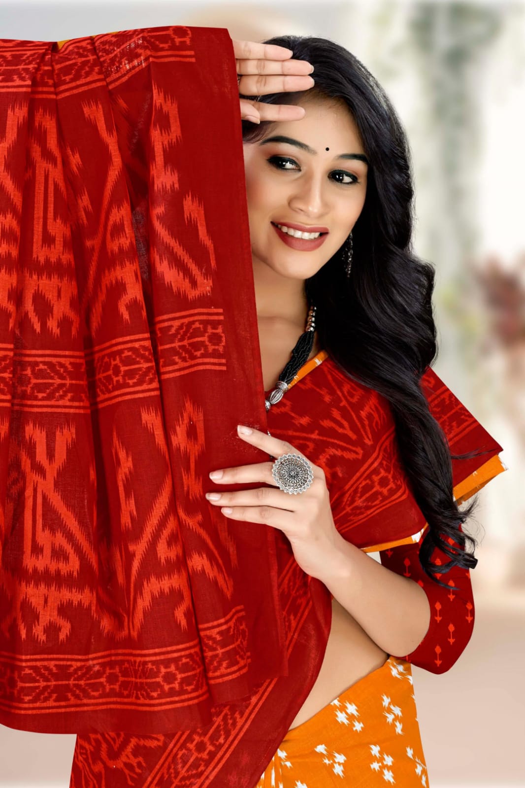 Beautiful pumpkin and dark red saree with handloom craftsmanship and tribal motifs, ideal for weddings.