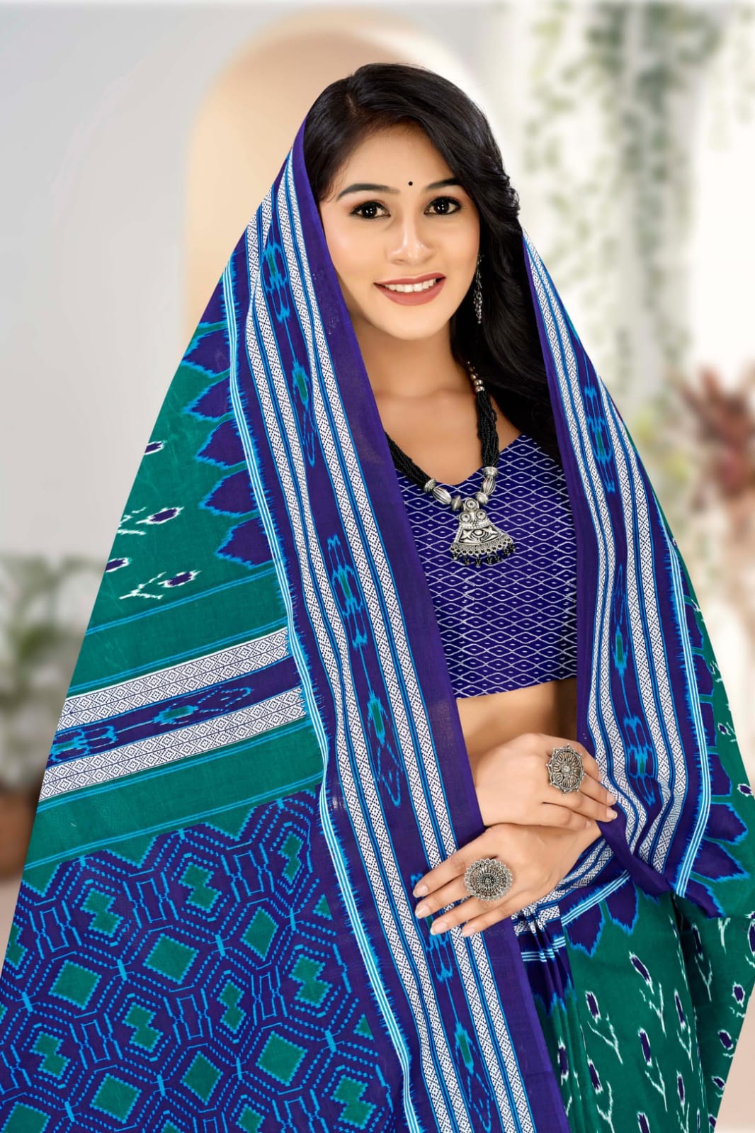 Pine green and blue handloom cotton saree with unique tribal detailing, perfect for celebrations.