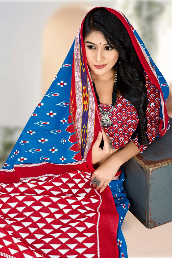 Handloom cotton blue and red saree with traditional tribal designs, ideal for elegant cultural gatherings.