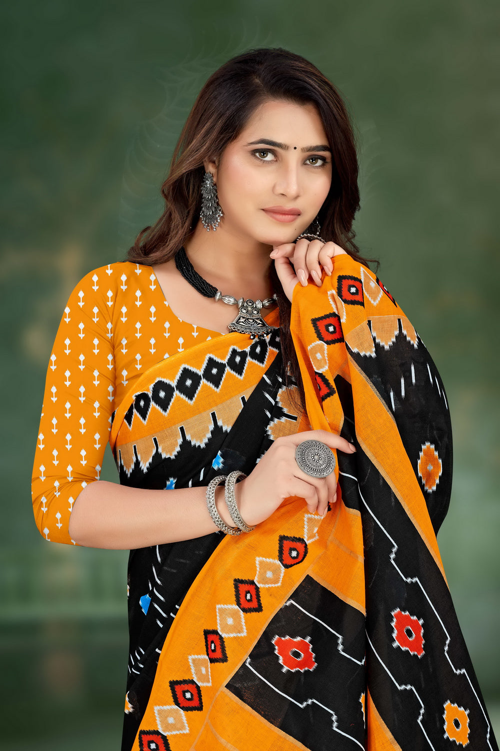 Traditional black and orange handloom saree with intricate cultural motifs, ideal for weddings and celebrations.