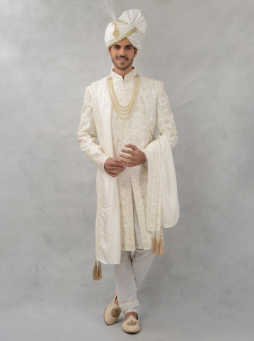 Make a lasting impression with this off-white silk blend sherwani, tailored for comfort and adorned with stunning embroidery, perfect for any wedding.