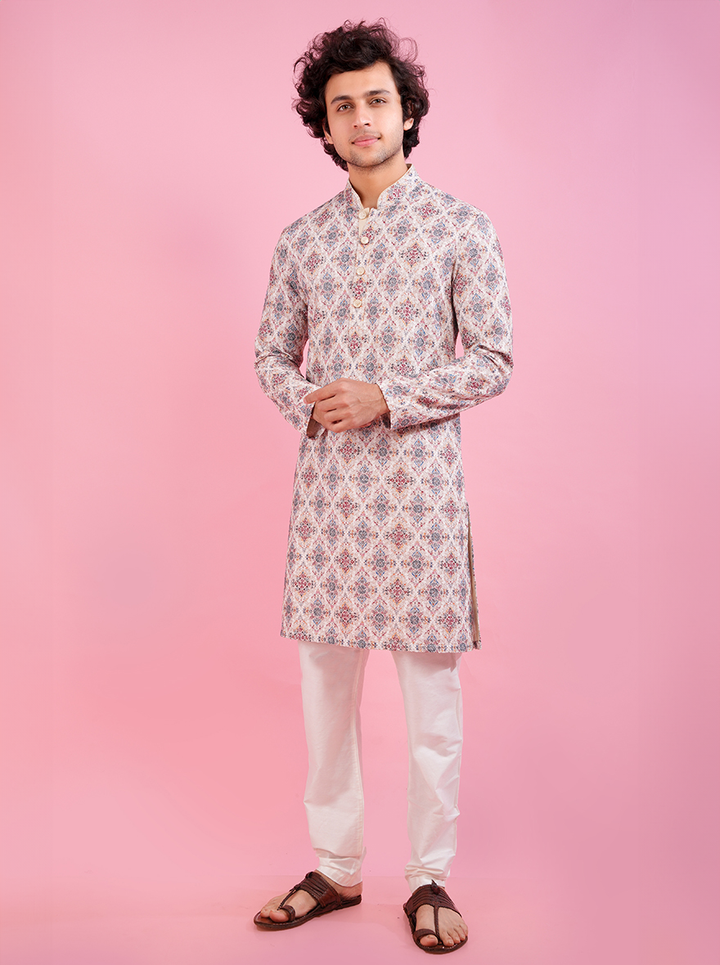 Traditional cream men's kurta pajama set with intricate embroidery for festive occasions.