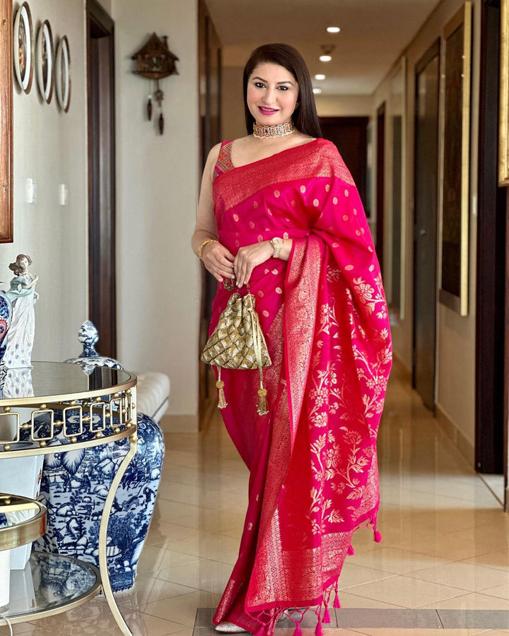 Hot pink Indian wedding saree with a luxurious zari border, fancy tassels, and a running blouse piece, perfect for weddings.