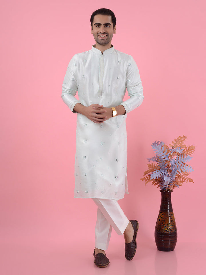 Men's light mint green kurta pajama set with intricate embroidery for traditional occasions.