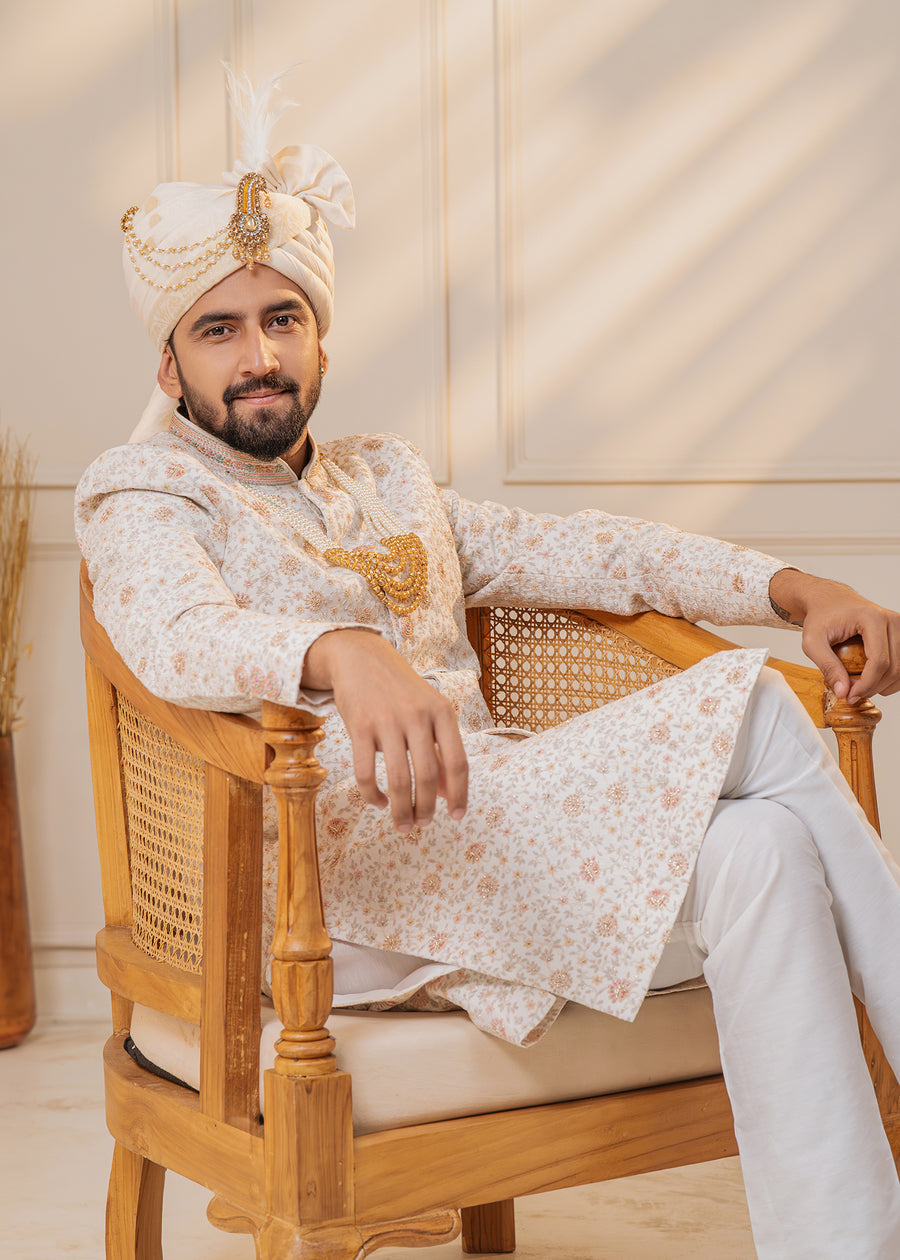 Make your USA wedding unforgettable with this off-white sherwani featuring zari thread work and peach highlights.