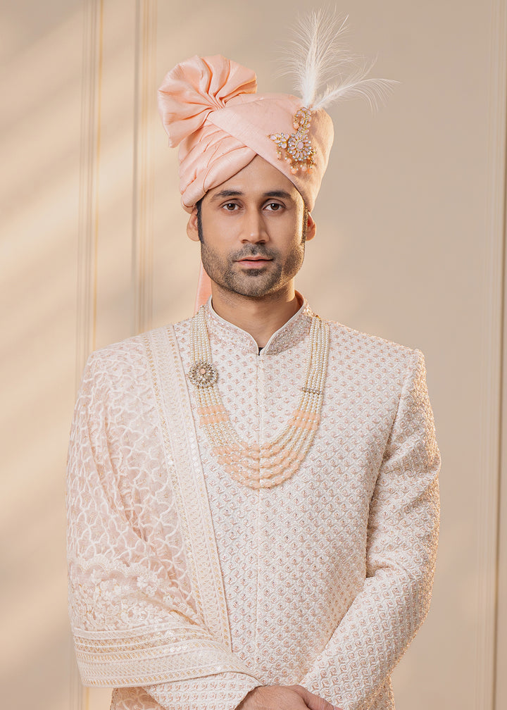 Achieve a classic yet modern look with this beautifully crafted off-white sherwani, designed for sophistication.