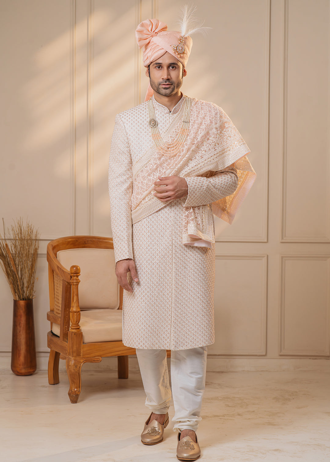 This off-white sherwani features stunning rose gold zardosi and cut-dana details, ideal for weddings.