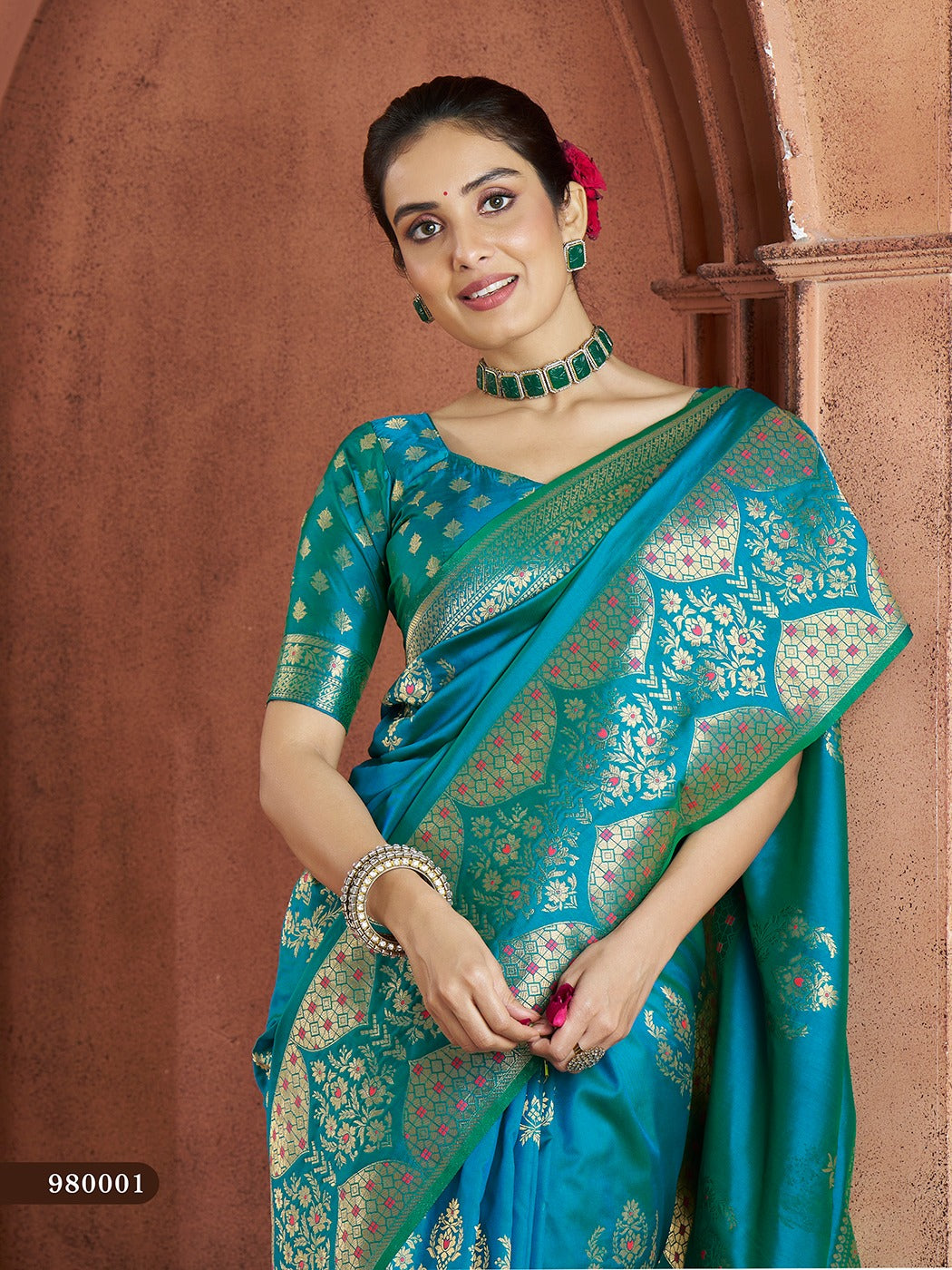 Rich teal-blue Banarasi saree with traditional motifs, silk blouse included.