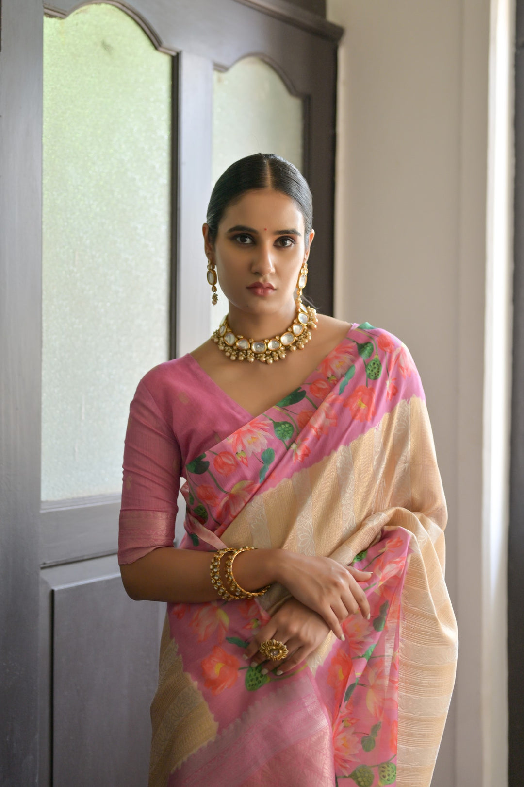 Lovely coral-orange soft silk saree with intricate Pichwai lotus print and rich zari pallu, ideal for festive wear.