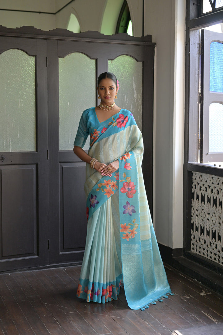 Soft sky-blue silk saree with beautiful flower prints and fancy lotus pattern pallu, perfect for elegant occasions.