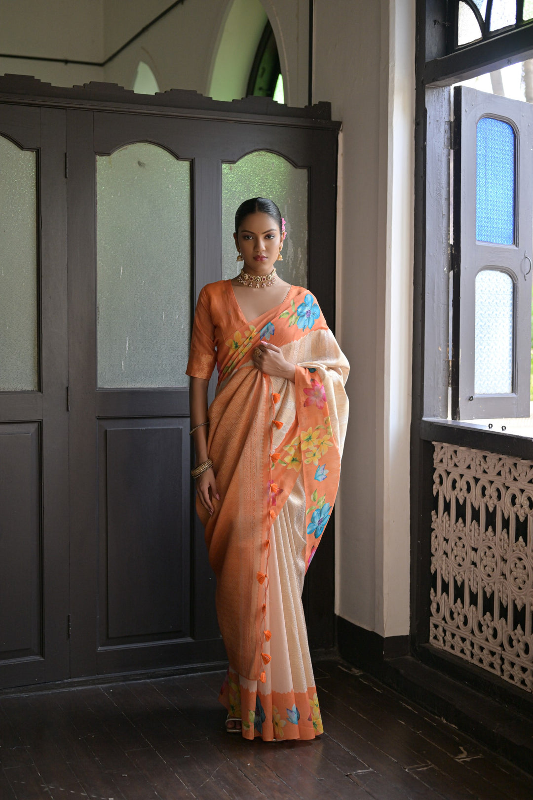 Vibrant orange silk saree with beautiful flower prints and a fancy lotus pattern pallu, adding elegance to your outfit.