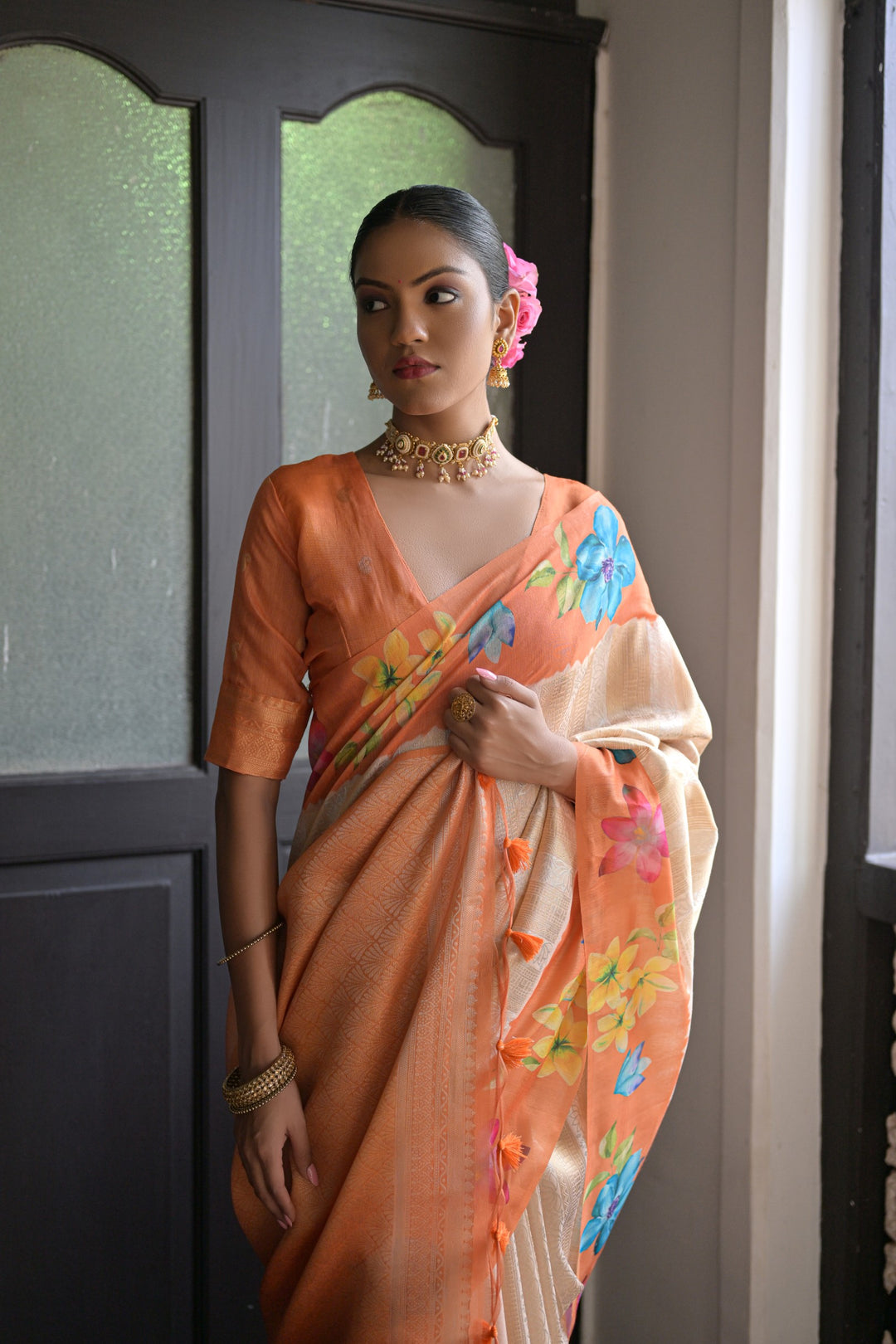 Gorgeous orange soft silk saree with delicate floral prints and a fancy lotus design pallu, perfect for brightening your wardrobe.