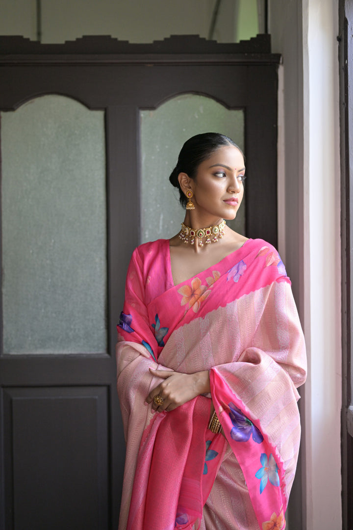 Elegant pink silk saree with delicate flower prints and a fancy lotus pattern pallu, perfect for festive gatherings.