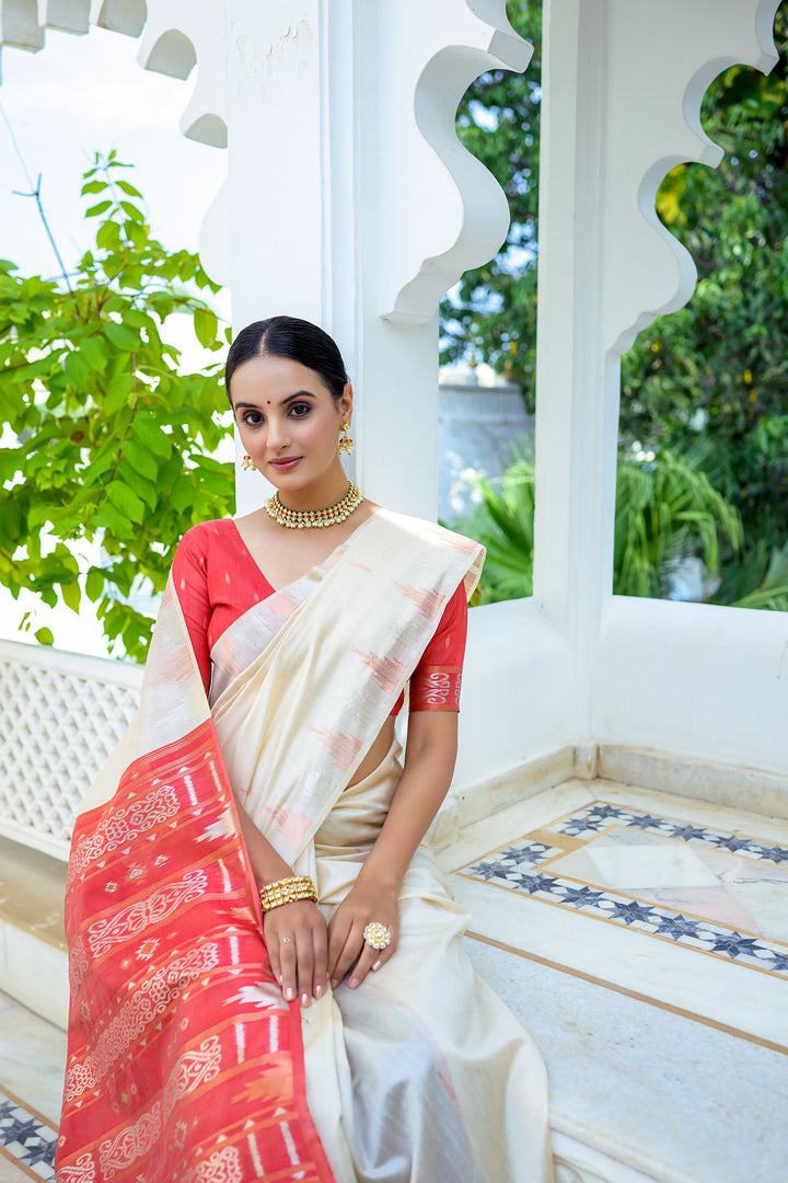 Classic off-white Tussar silk saree with a designer temple border and colorful Ikkat pallu, perfect for traditional celebrations.