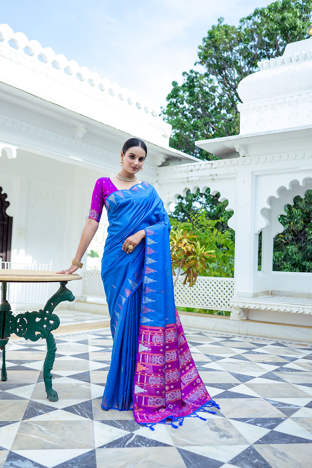 Bold teal Tussar silk saree with elegant temple border and colorful Ikkat pallu, ideal for cultural gatherings.