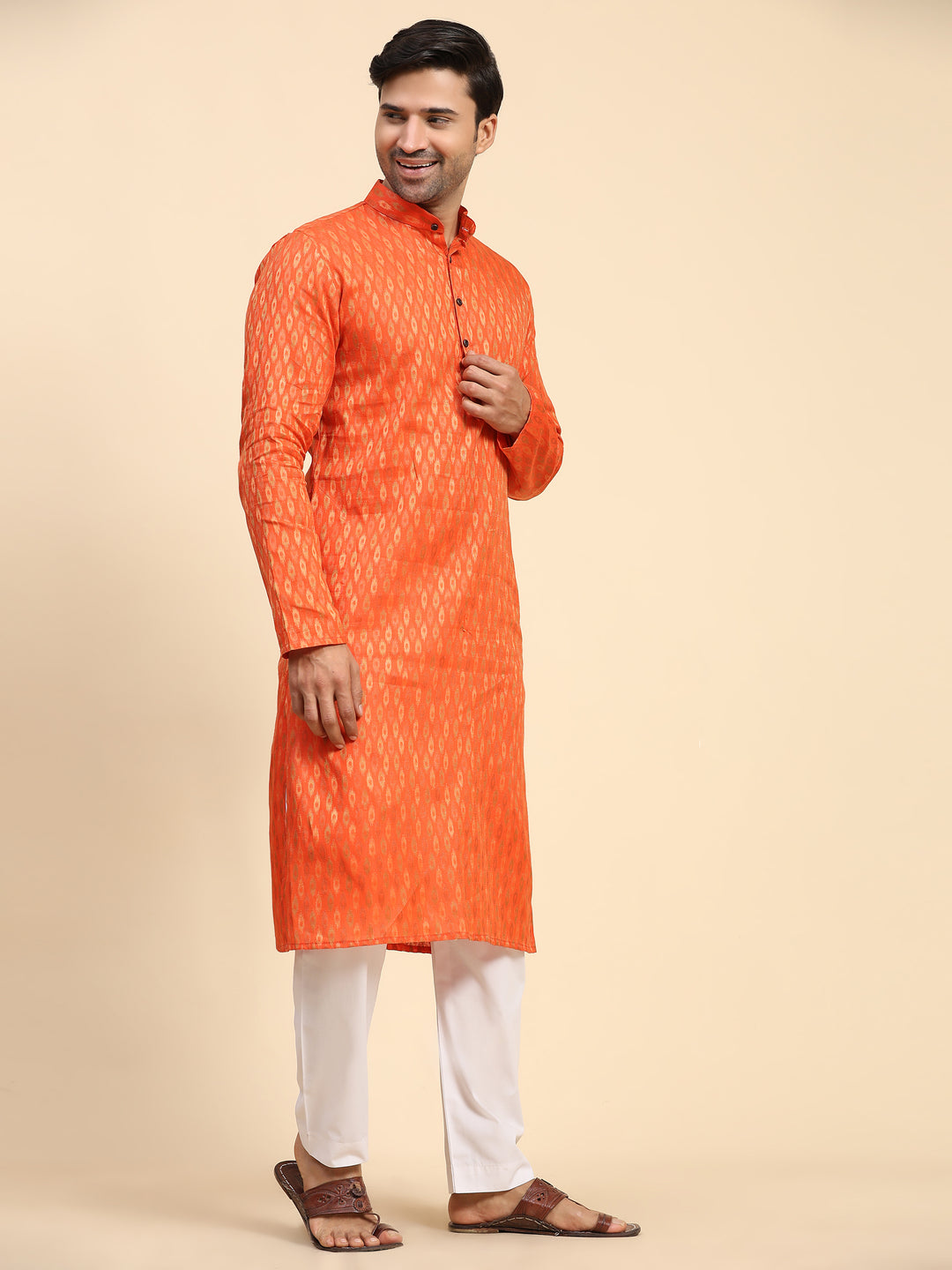 Traditional orange kurta pajama set for men with beautiful handwoven motifs for festive wear.