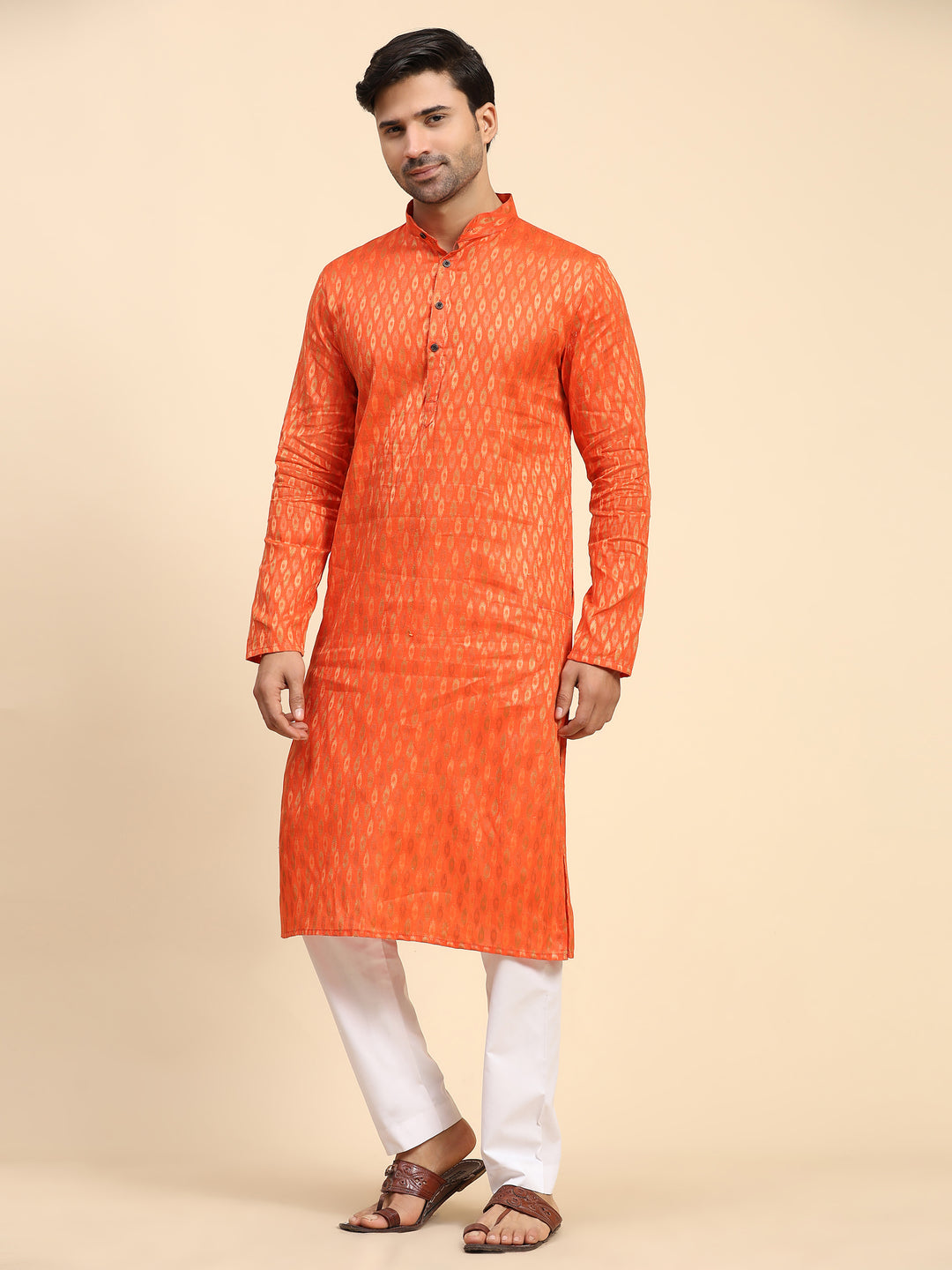 Elegant orange kurta set for men with handwoven details, ideal for weddings and cultural events.