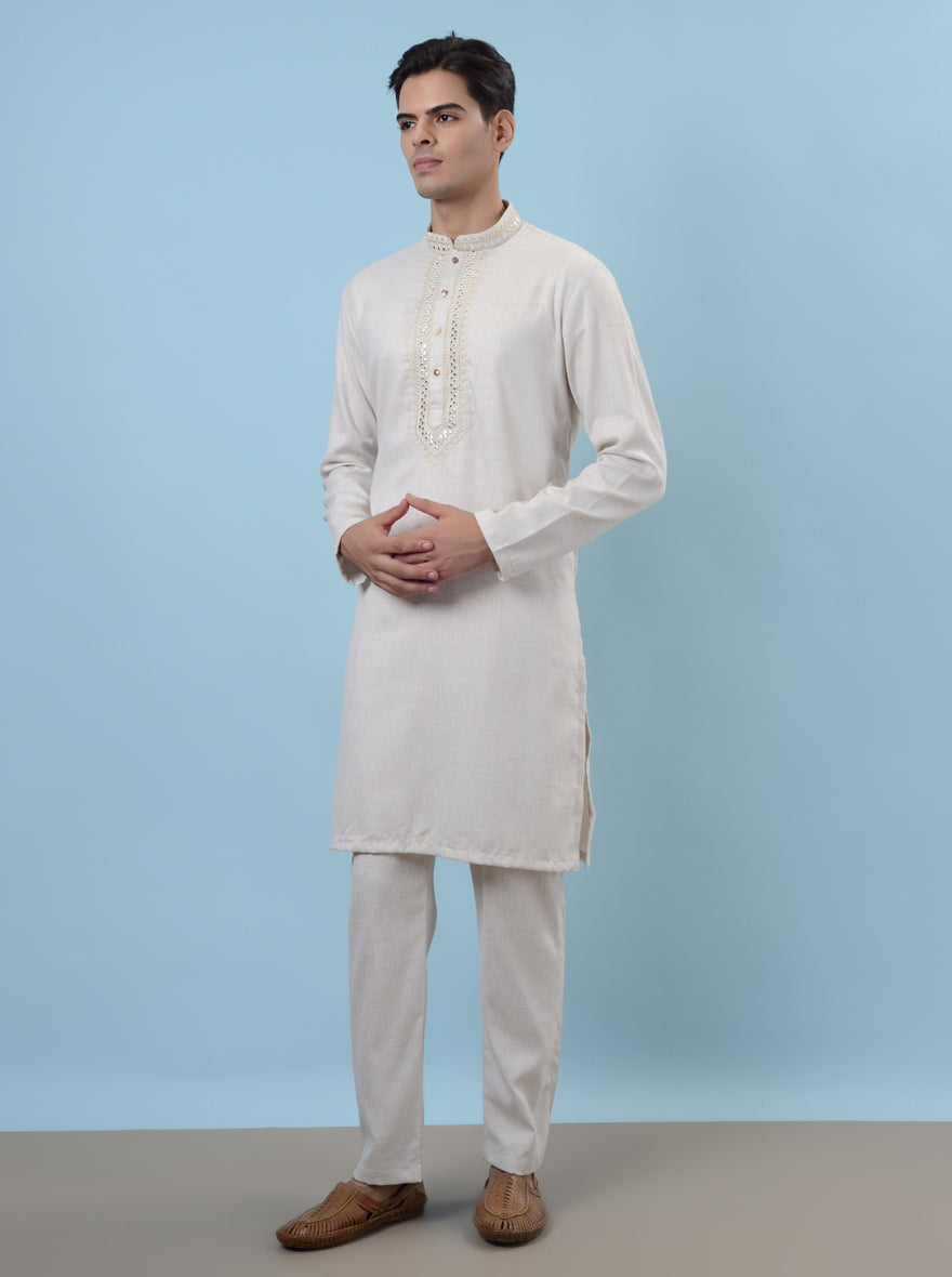 Elegant white kurta pajama featuring detailed mirror work, perfect for memorable occasions.