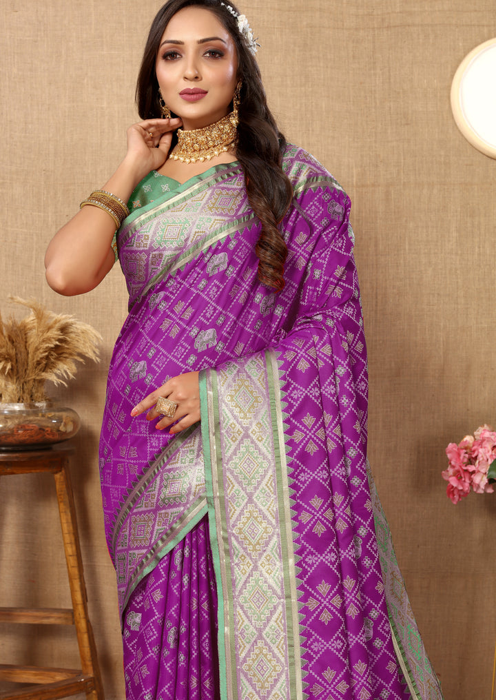 Sophisticated purple Patola silk sari featuring intricate zari and pallu, ideal for cultural gatherings.