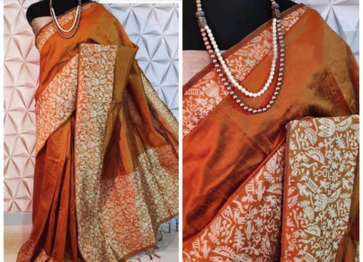 Elegant orange raw silk saree with intricate pallu detailing, ideal for Indian weddings.