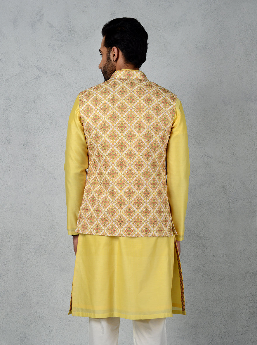 This sleeveless yellow Jodhpuri jacket combines silk fabric with intricate thread embroidery and a mandarin collar, perfect for celebrations.