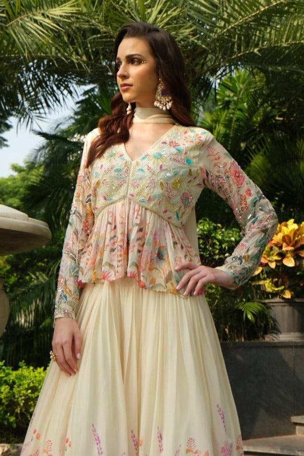 Stylish cream lehenga with peplum design and gotta work detailing, ideal for festive occasions.