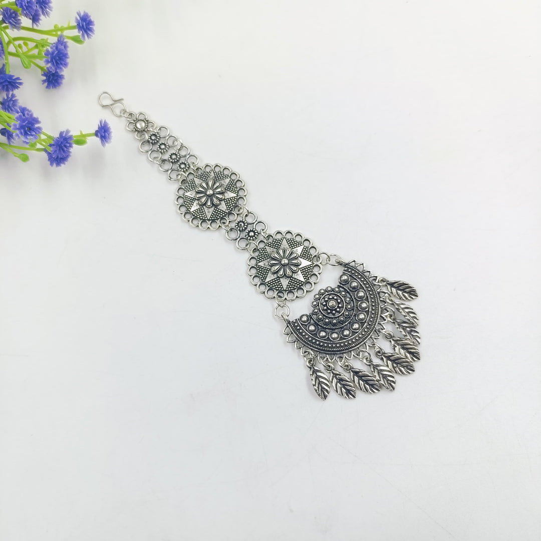 Intricate oxidised tikka designed to complement various bridal looks at weddings.