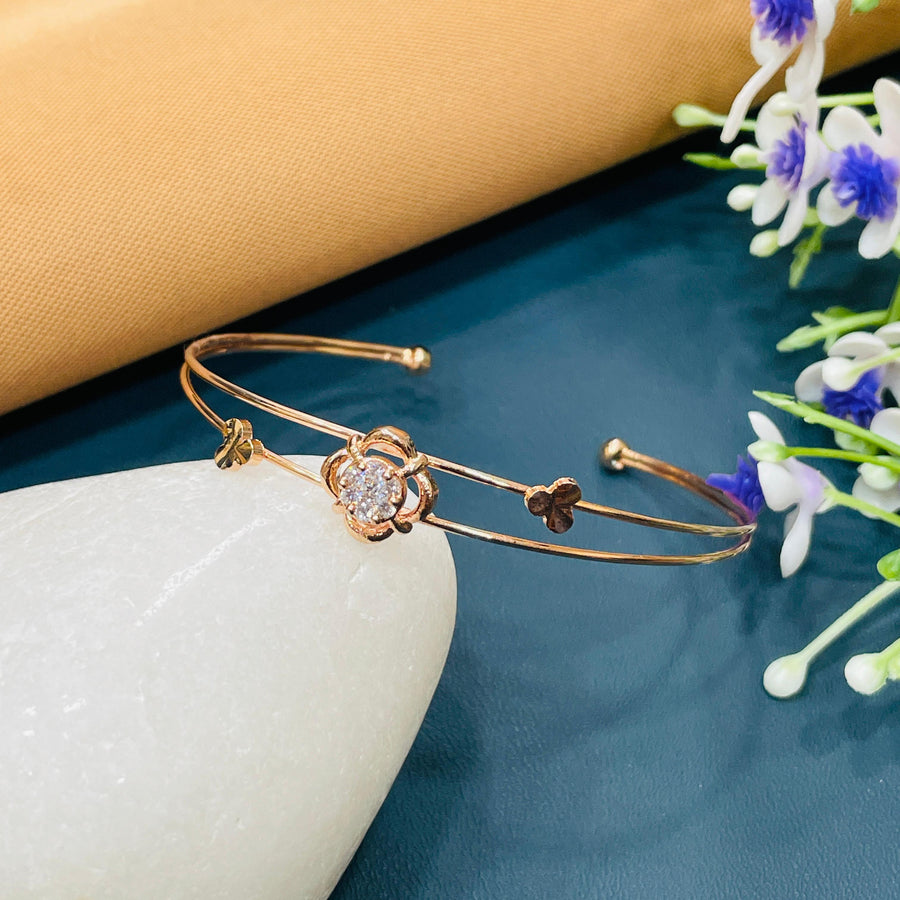 Elegant rose gold cuff bracelet with an open twist design, adding unique style.