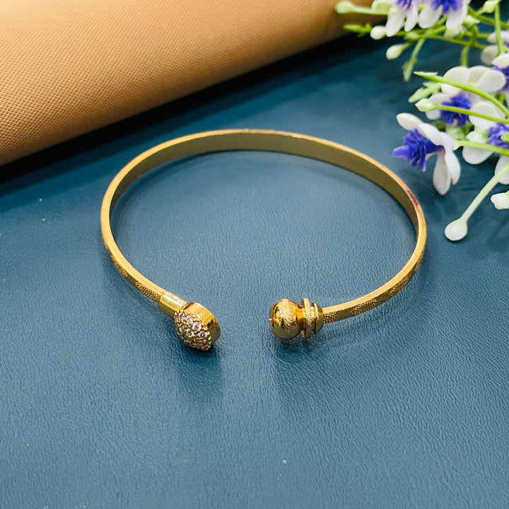 Sophisticated golden bracelet with a smooth cuff design, perfect for parties.