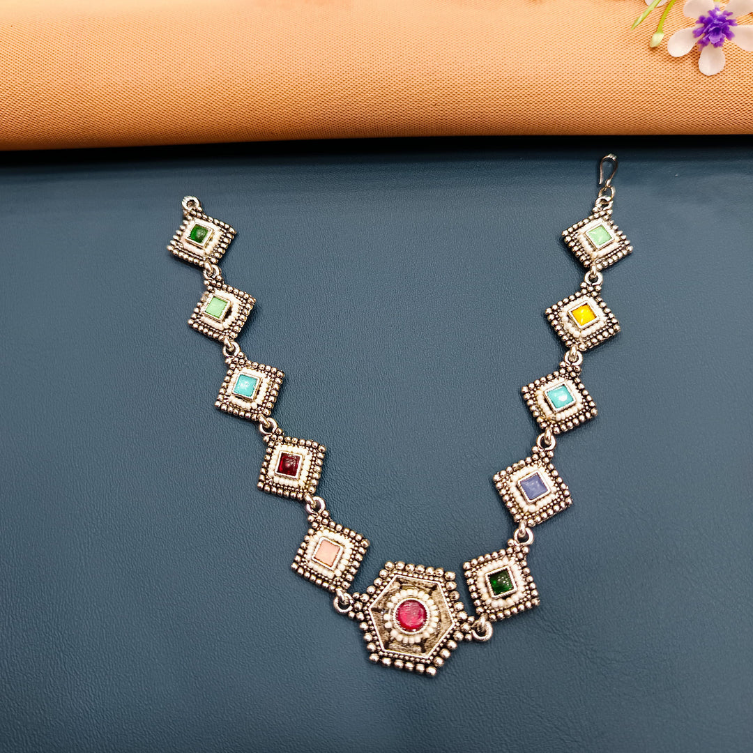 Stunning oxidised tikka with detailed patterns, perfect for ethnic wedding attire.