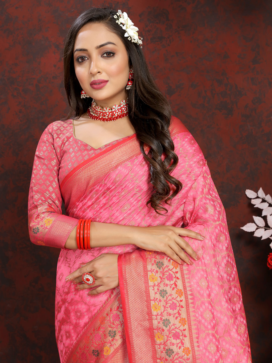 Beautiful coral pink Meenakari organza silk saree with delicate zari border and tassels, perfect for weddings.