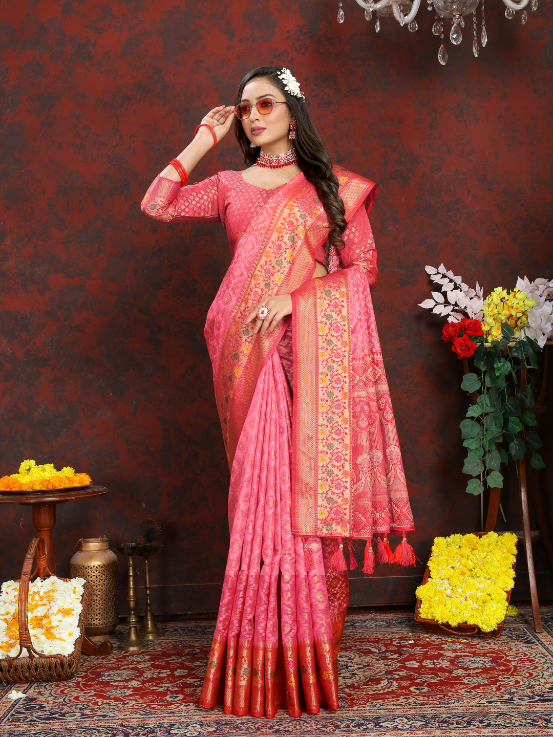 Gorgeous coral pink saree with intricate Meenakari weaving and a zari border, accented with tassels at the pallu.