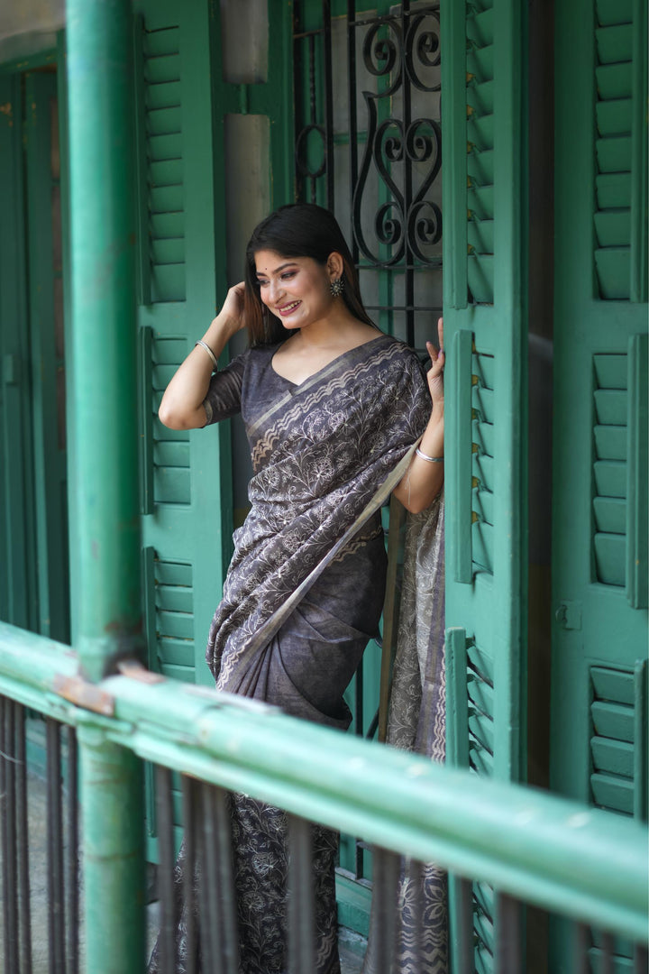 Elegant gray Tussar silk saree featuring intricate batik border design and fancy tassels, perfect for festive events.