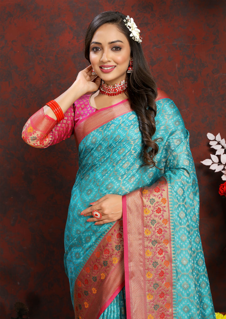 Elegant turquoise saree in Meenakari organza silk, with intricate zari border and pallu tassels for festive events.