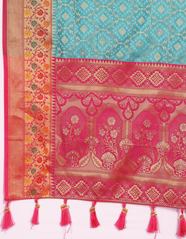 Stunning turquoise Meenakari organza silk saree with a zari border and tasseled pallu, ideal for elegant celebrations.