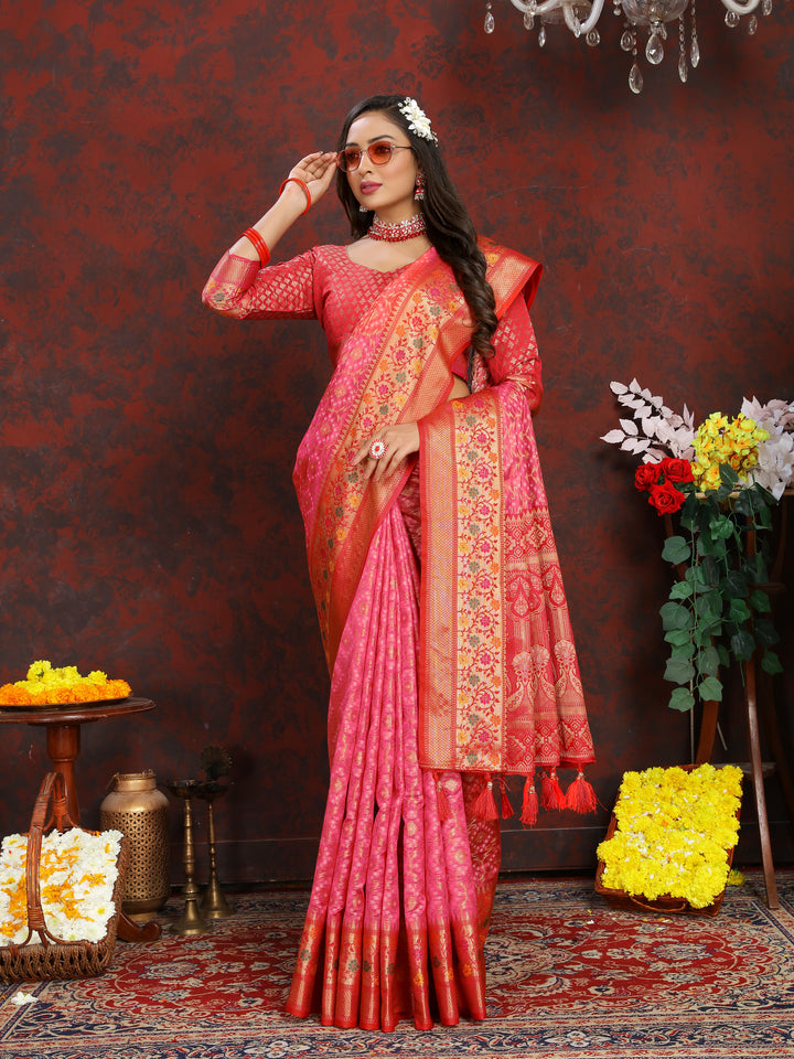 Elegant pink Meenakari organza silk saree with intricate zari work and tassels at the pallu, ideal for festive occasions.