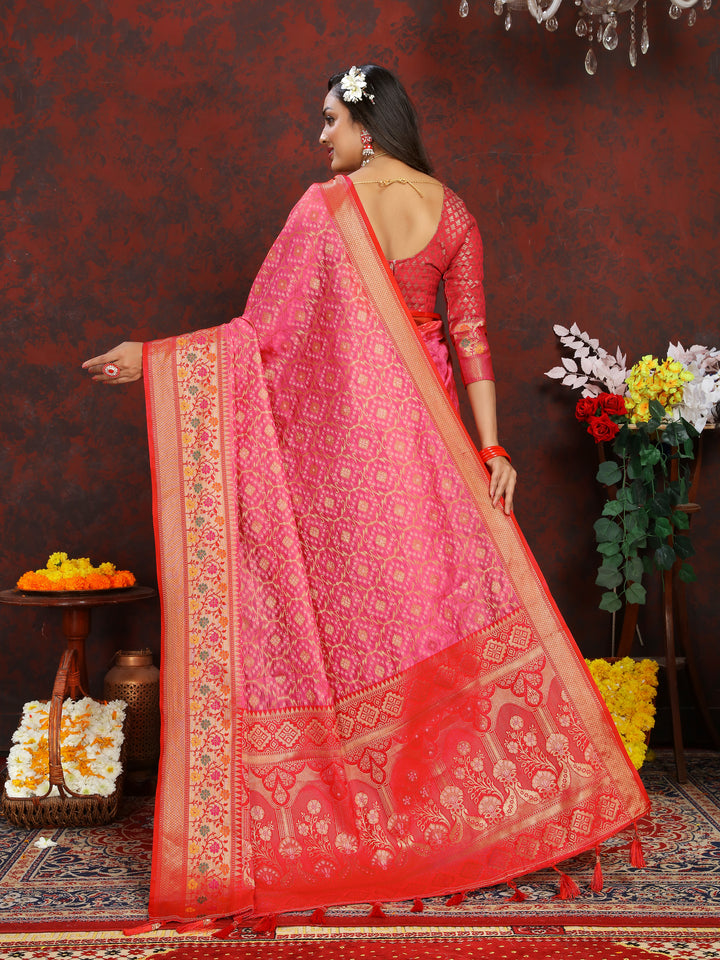 Graceful pink Meenakari organza silk saree with a zari border and pallu tassels, perfect for special celebrations.