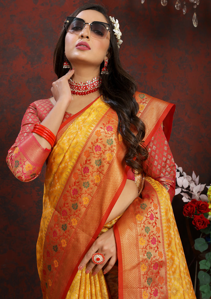 Timeless yellow Meenakari organza silk saree with intricate zari border and tassels, perfect for festive occasions.