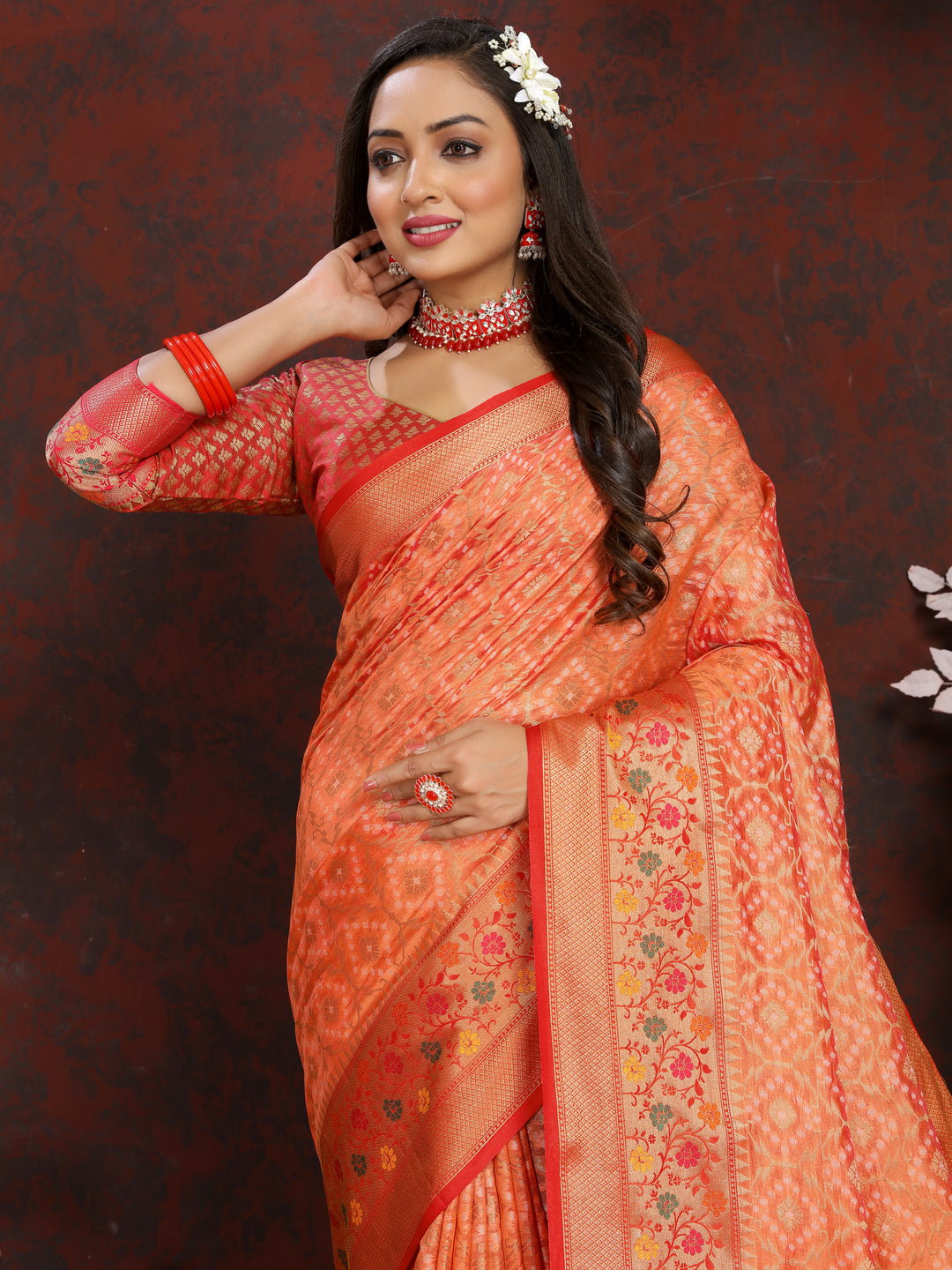 Beautiful orange Meenakari organza silk saree with a zari border and tassels at the pallu, ideal for weddings.