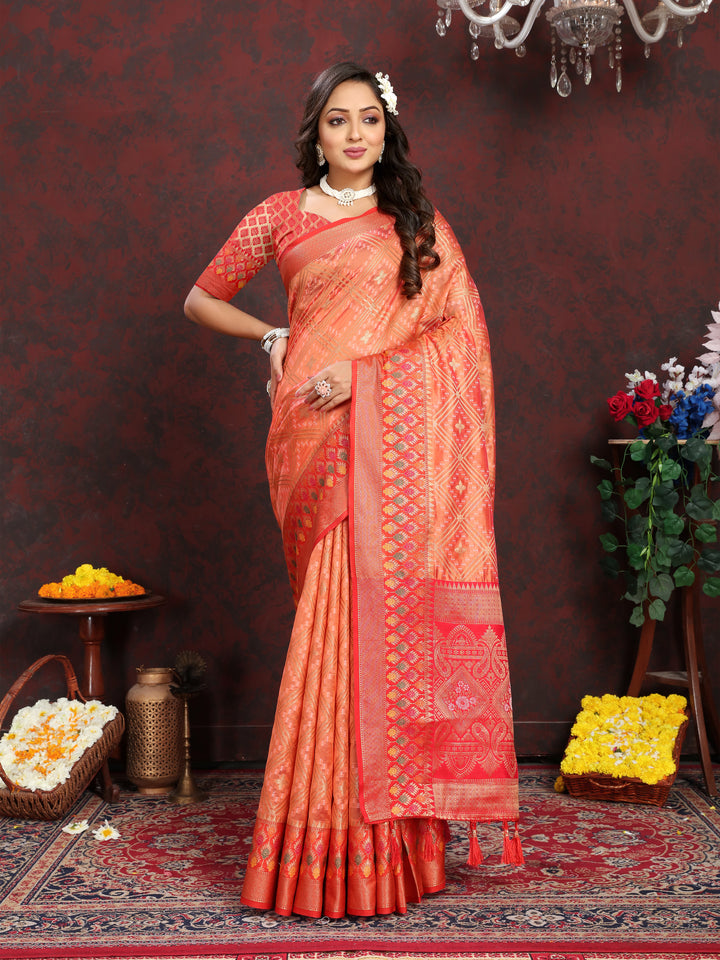 Elegant orange Organza silk saree with intricate zari weaving and Meenakari pallu, perfect for festivals.