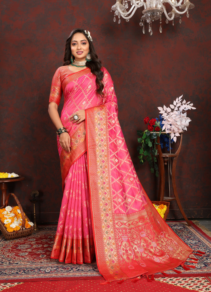 Vibrant bright pink Organza sari with intricate design and matching blouse piece, ideal for weddings.