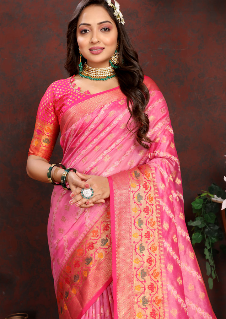 Beautiful pink organza saree featuring delicate patterns and a matching blouse piece, perfect for traditional gatherings.